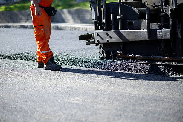 istock Construction worker operates asphalt paving machine on city street during daytime 2208086396