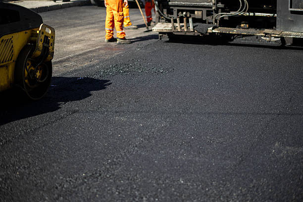 istock Workers performing road construction with an asphalt paver and roller in a city setting during daylight hours 2208086406