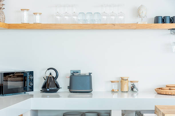 istock Simple modern kitchen with white counter and wooden top and kitchenware in the cabinets 2208086622