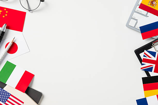 istock Flat lay: International flags (USA, UK, China, Japan, Germany, etc.) surround copy space on white desk. Concept for language, global business, travel, education. 2208087894
