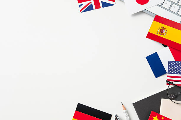 istock Flat lay International flags (UK, Japan, Spain, France, USA, Germany) and keyboard frame copy space on white desk. Global business, language learning concept. 2208087899