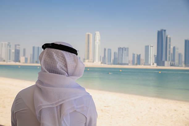 istock Businessman looking to city from beach 2208089009