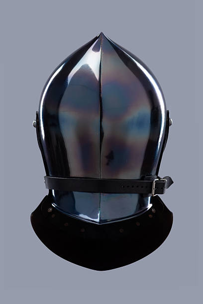 istock Dark Shiny Closed Helmet with Ventilation Holes. This image shows a dark, shiny helmet, possibly made of blackened steel, with a smooth, rounded shape and several small ventilation holes on the front. 2208089788