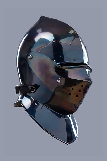 istock Dark Shiny Closed Helmet with Ventilation Holes. This image shows a dark, shiny helmet, possibly made of blackened steel, with a smooth, rounded shape and several small ventilation holes on the front. 2208089826