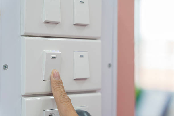istock A person pressing a light switch, close up. The switch tilts slightly with a soft click 2208090662