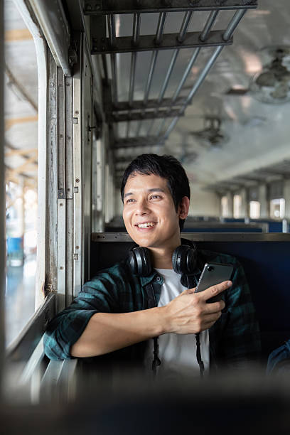 istock Journey and Anticipation. A young man enjoys his smartphone during a train ride. 2208090739
