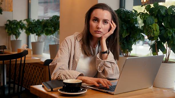 istock Tired bored overworked depressed working freelance distant work from cafe Caucasian cafeteria visitor woman female business girl businesswoman typing laptop stress boring job unmotivated burnout sad 2208098183