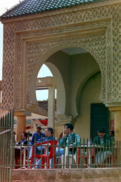 Morocco, Marrakesh - July 1997: Locals enjoy their coffee or cold drinks on a coffee terrace in the old Medina bazaar.\nPlease note that this over twenty-five year old image was taken in 1997 and converted from the negative.