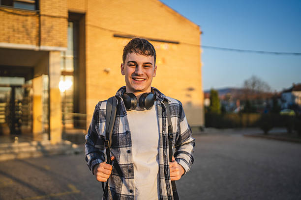 istock young man with wear backpack in front university building 2208098585