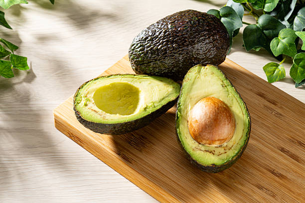 istock Fresh organic avocado on wooden table 2208099673