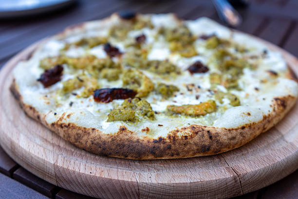 istock Pizza with a white cream cheese base and shrimp in pesto. 2208100832
