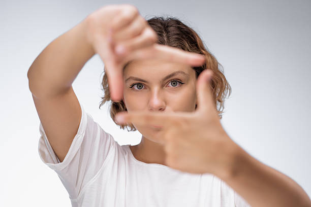 istock Focused Woman Framing Face with Hands in Creative Gesture 2208101375