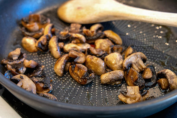 Fried in vegetable oil champignons in a frying pan