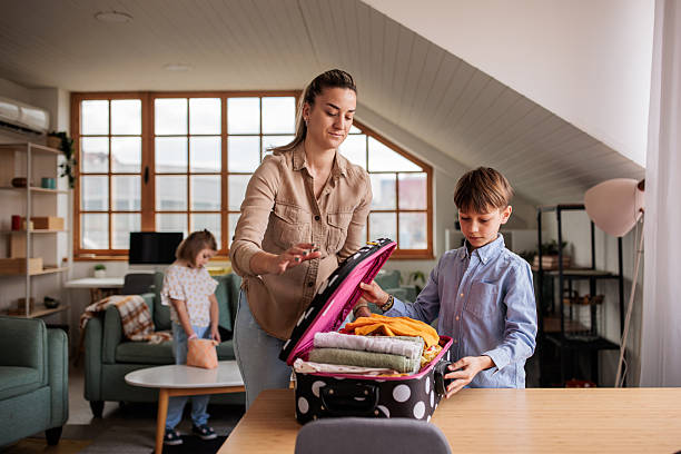 istock Mother packing a suitcase with her son for a trip 2208103018