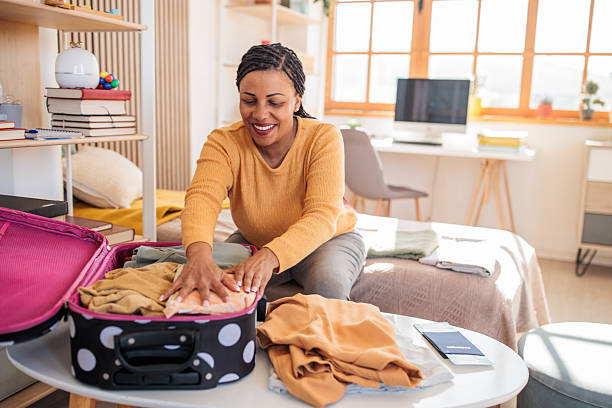 istock Woman packing a suitcase for a trip at home 2208103458