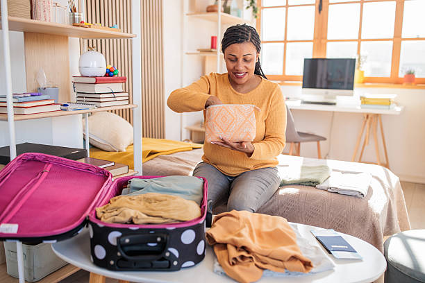 istock Woman packing a suitcase for a trip at home 2208103476