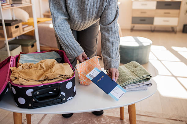 istock Woman packing a suitcase for a trip at home 2208103561