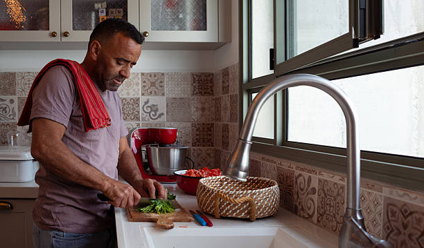 istock Man Chopping Fresh Herbs in Cozy Kitchen. 2208103995