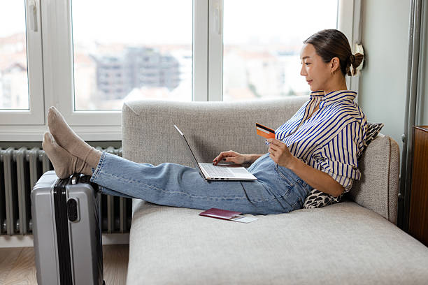 istock Woman planning her vacation online while relaxing at home with a suitcase 2208105957
