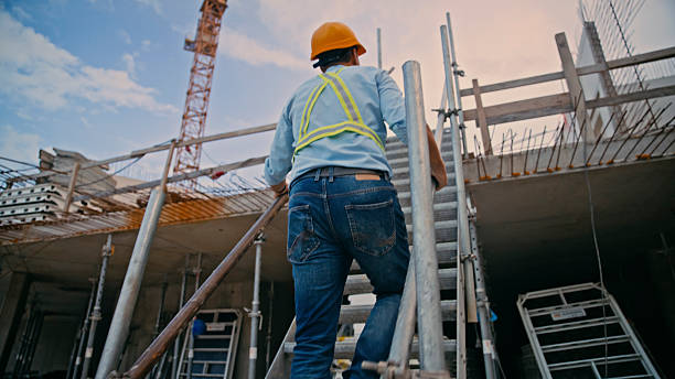 istock Construction Worker Climbing Ladder at Building Site with Steel Framework Under Clear Sky 2208108967