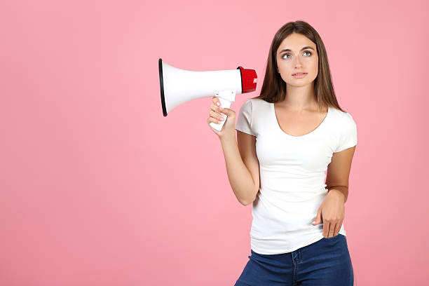 istock Young woman with megaphone on pink background 2208108986