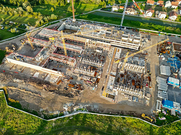 istock Aerial View of Large-Scale Construction Site with Cranes and Building Framework in Progress 2208109003
