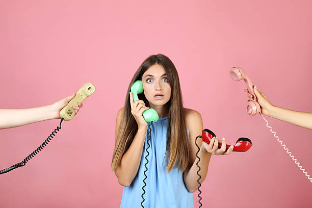 istock Young woman and two hands with handsets on pink background 2208109133