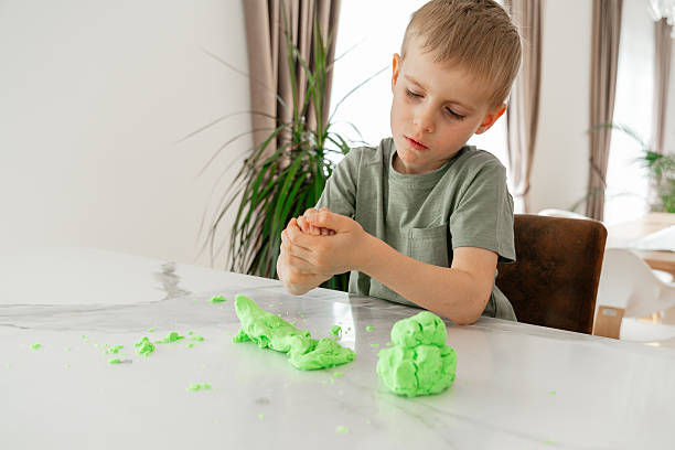 istock Focused Child Sculpting with Green Play Dough 2208109358