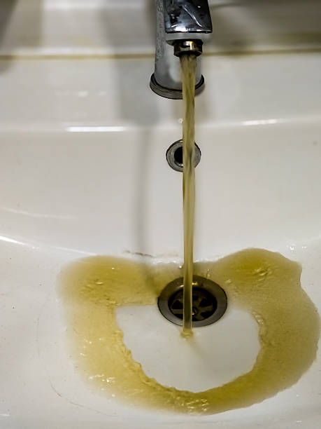 istock Rusty or dirty water flowing from tap into white bathtub or sink 2208109504
