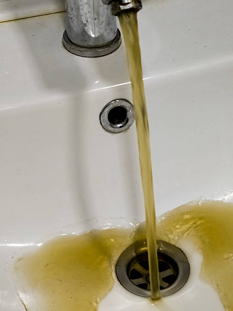 istock Dirty dark brown running water falling into sink from tap. Polluted fresh water 2208109505