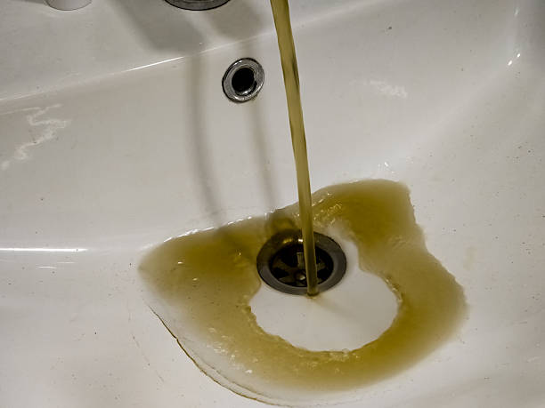 istock Rusty or dirty water flowing from a tap into a white bathtub or sink 2208109515