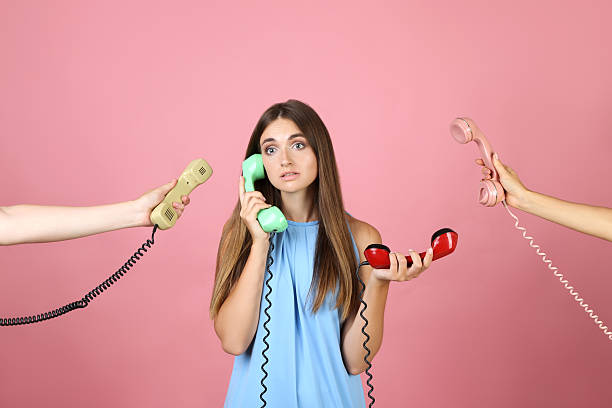 istock Young woman and two hands with handsets on pink background 2208109520