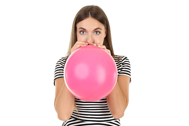 istock Young woman blowing pink balloon on white background 2208109811