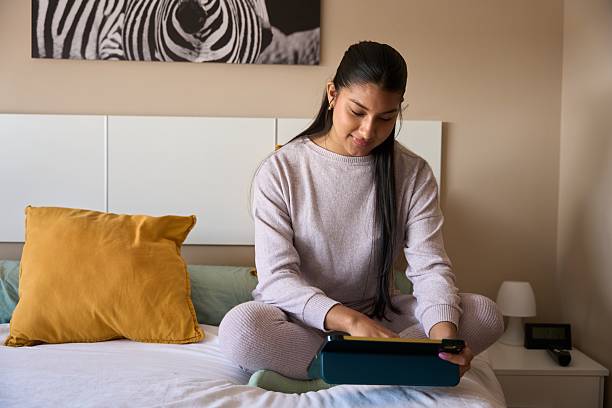 istock Young woman using digital tablet on bed in bedroom 2208110641