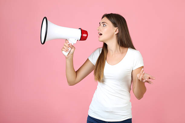 istock Young woman with megaphone on pink background 2208110872