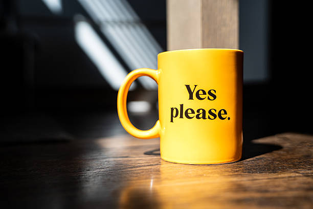 istock Bright yellow coffee mug with the phrase “Yes please.” 2208110915