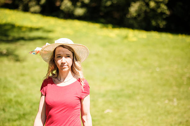 Young woman walking in a field on a sunny summer day