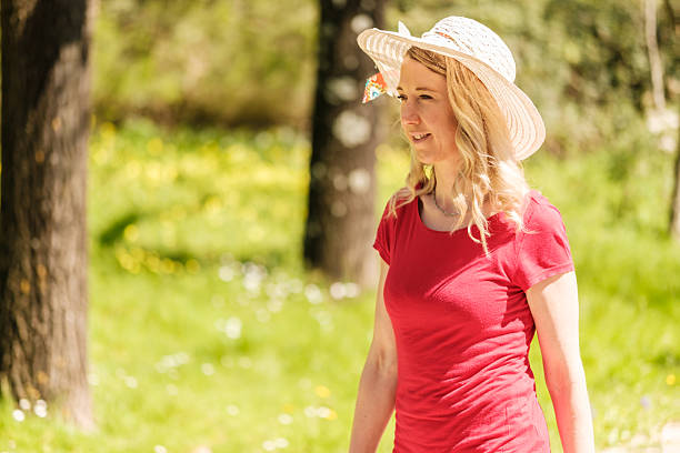 istock Woman walking on a path in a sunny park 2208112528