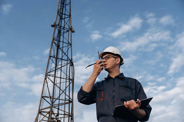 istock Smart guy is talking by using walkie talkie. Construction worker is near boring drilling machine 2208122050