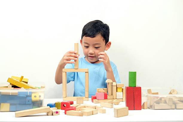 istock A young boy builds creative structures with colorful wooden blocks 2208124884