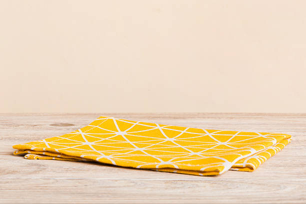 istock top view with yellow empty kitchen napkin isolated on table background. Folded cloth for mockup with copy space, Flat lay. Minimal style 2208127626