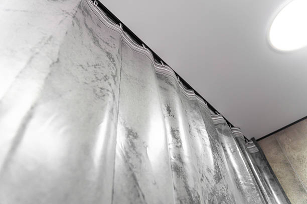 istock Modern gray curtains are hanging from a ceiling track system, adding a touch of elegance and style to the interior design of a contemporary apartment 2208127824