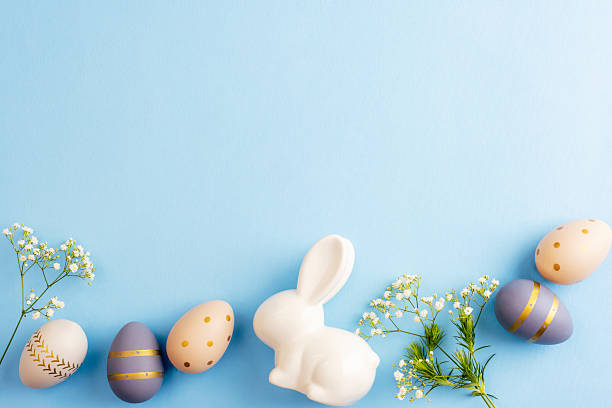 istock Easter eggs, flowers and ceramic bunny on blue background. Easter concept. Top view, flat lay, copy space 2208128142
