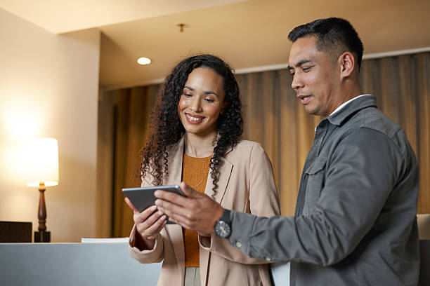 istock Business Professionals Engaging in a Discussion Using a Tablet in a Modern Hotel Lobby 2208131734