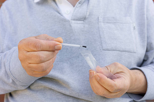 istock Man Removing Topical Ointment Applicator Brush from Clear Plastic Mini Grip Seal Bag 2208134302