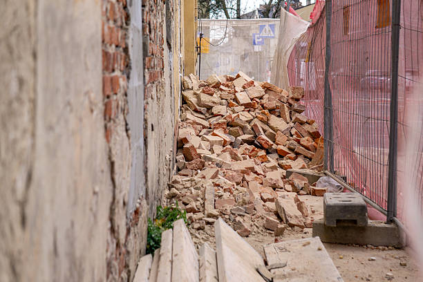 a lying brick on the ground. a secured construction site. demolition of an old red brick residential building in the city center. demolition of a residential building. a ruin, a falling apart building.
