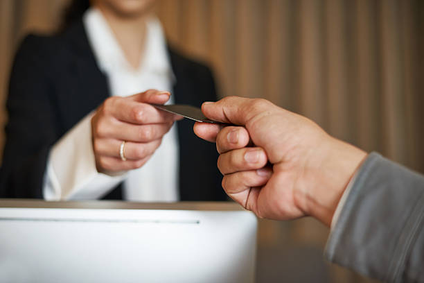 Receptionist Handing Card to Guest in a Modern Hotel Lobby Setting