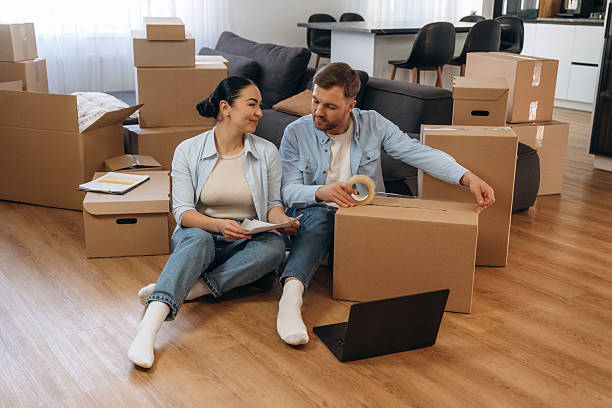 istock Using scotch to pack the box. Happy couple moved into new house 2208137132