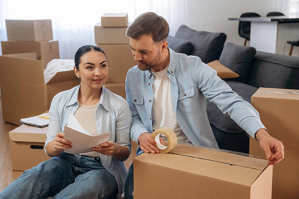 istock Closing the box, using scotch. Happy couple moved into new house 2208137173