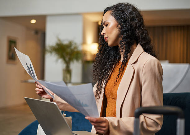 Businesswoman Analyzing Documents in a Modern Hotel Lobby Setting